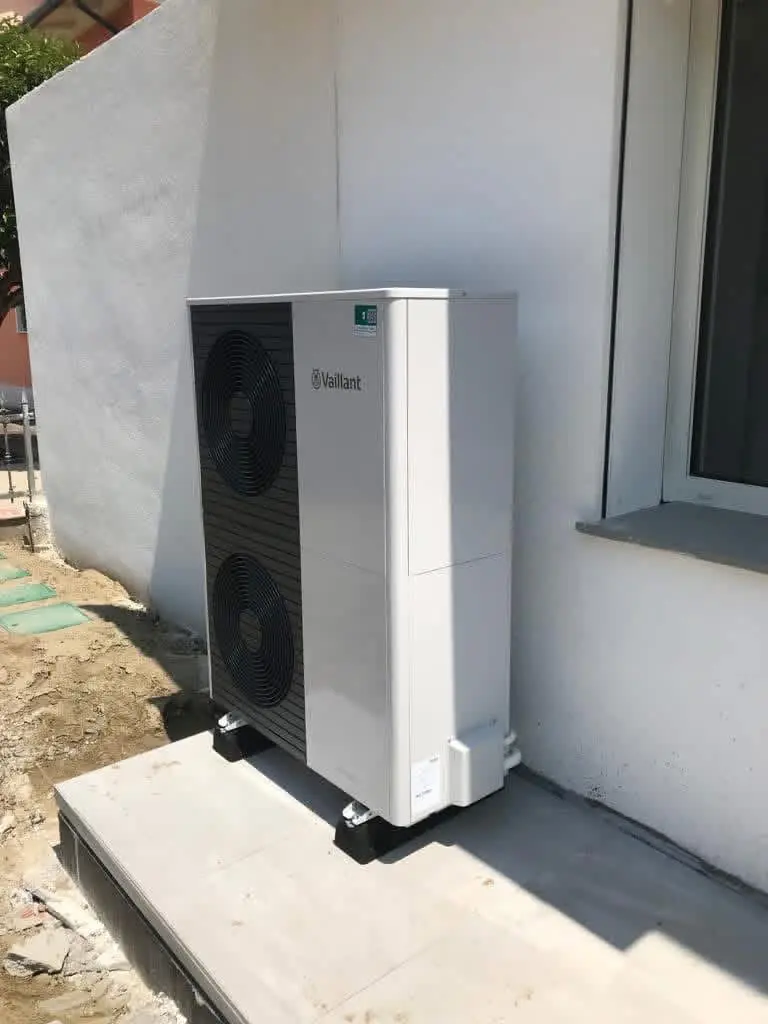 Unità esterna di una pompa di calore Vaillant accanto all'edificio